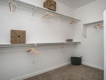 Walk-in closet with hanging rods and storage baskets